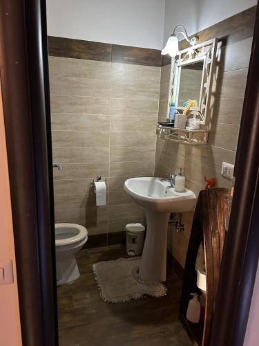 a bathroom with a sink and a toilet and a mirror at Maison Gaia in Velletri