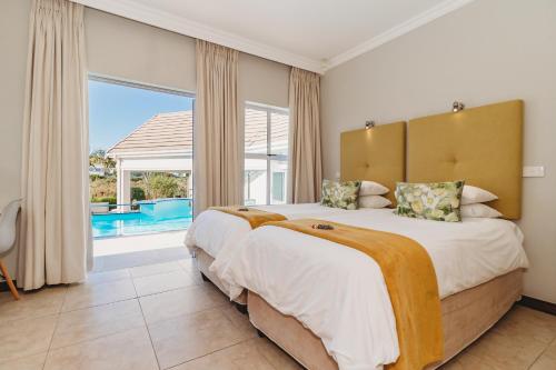 Un dormitorio con una cama grande y una ventana grande. en GolfersHeaven Kingswood Golf Estate, en George