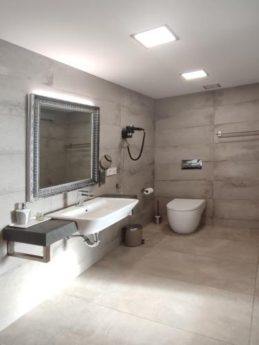a bathroom with a sink and a toilet and a mirror at VillasRoyale Diamante - A Diamond to Discover! in Meloneras