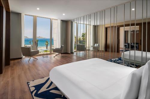 a bedroom with a bed and a view of the ocean at Swissôtel Resort Bodrum Beach in Turgutreis