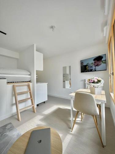 Cette chambre blanche dispose d'une table et d'un lit. dans l'établissement Studio neuf en bord de Seine, à Rouen