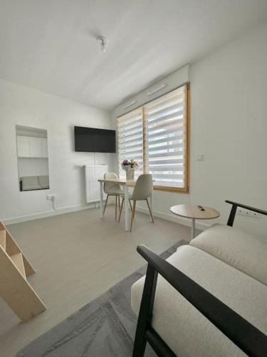 un salon avec un canapé et une table dans l'établissement Studio neuf en bord de Seine, à Rouen