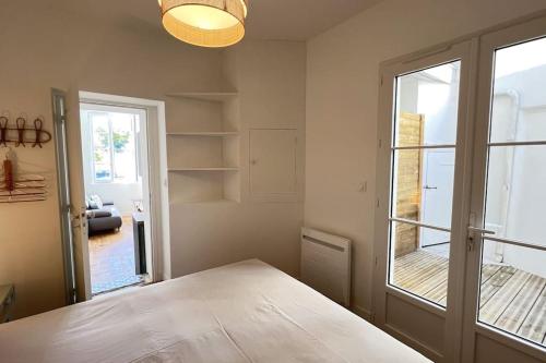 une pièce avec une table et une grande fenêtre dans l'établissement La Corderie - Appartement sur le Quai aux Vivres, à Rochefort