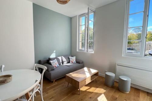 un salon avec un canapé et une table dans l'établissement La Corderie - Appartement sur le Quai aux Vivres, à Rochefort