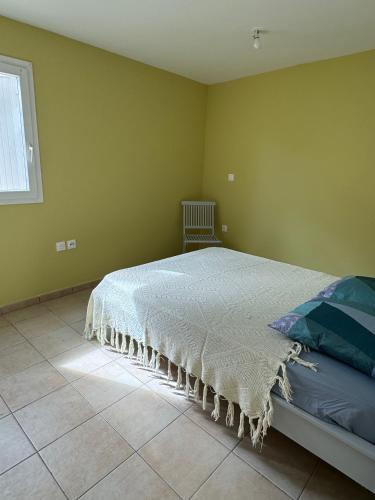 a bedroom with a bed in a room with a window at Appartement F2 résidence calme avec piscine SAINT-ANDRE in Saint-André