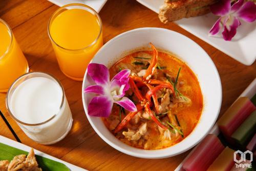 a bowl of soup with a flower on a table at ON Thapae Gate Chiangmai in Chiang Mai