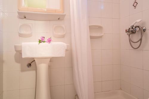 un bagno con lavandino e fiori di Tota Studios a Tsilivi