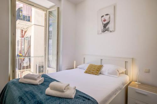 une chambre avec un lit avec des serviettes dessus dans l'établissement Maison Bianchi - Place Marshall, à Nice