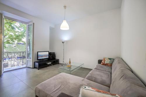 un salon avec un canapé et une télévision dans l'établissement Maison Bianchi - Place Marshall, à Nice