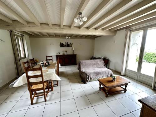un salon avec un lit et une table dans l'établissement Maison de campagne proche Vichy, à Saint-Étienne-de-Vicq