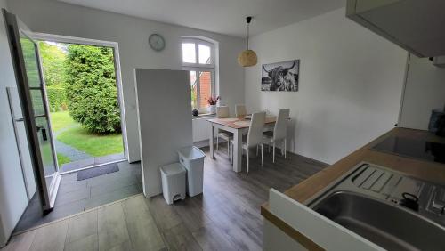 a kitchen and dining room with a table and chairs at Ferienwohnung Emma s Fehnhaus, 55183 in Stickhausen