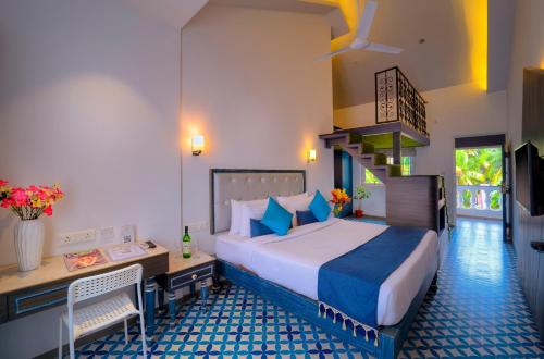 a bedroom with a bed and a desk and a staircase at TreeHouse Nova in Cansaulim