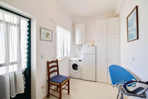 a living room with a blue chair and a washing machine at Alcaria Grand House in Altura