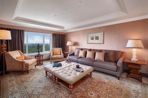 a living room with a couch and a table at Taj Palace, New Delhi in New Delhi