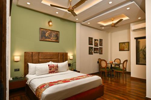 a bedroom with a large bed and a dining room at Hotel Sethi Legacy in Haridwār