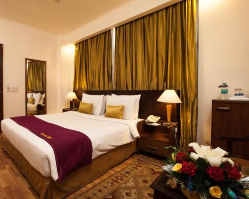 Habitación de hotel con cama y mesa con teléfono en FabHotel Goodwill GK 1 en Nueva Delhi