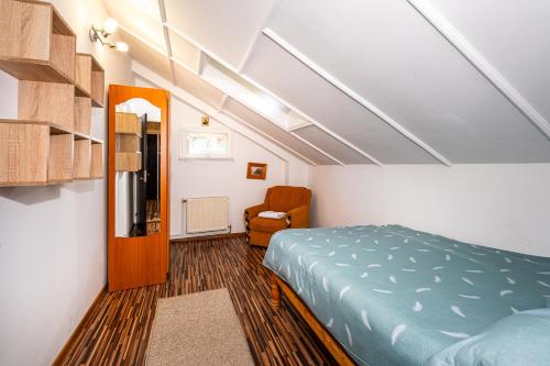 a bedroom with a bed and a chair in it at Breazary in Breaza de Jos