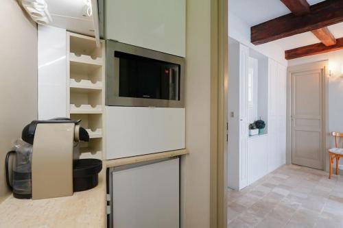 un salon avec une télévision sur un mur dans l'établissement Cœur du Marais - Grand appartement 4 personnes, à Paris