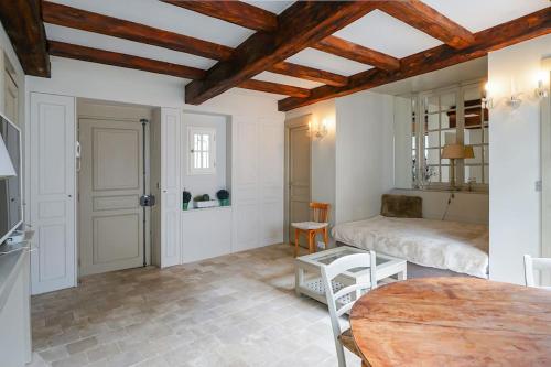 un salon avec une table et un lit dans l'établissement Cœur du Marais - Grand appartement 4 personnes, à Paris