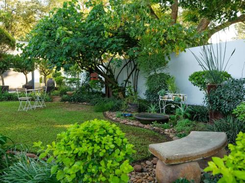 a garden with a stone bench and a tree at Nadora's Rest in Kirkwood