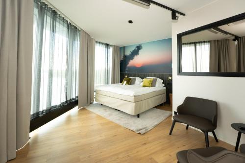 a bedroom with a bed and a chair at Break Sokos Hotel Bomba in Nurmes