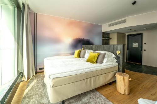a bedroom with a large bed with yellow pillows at Break Sokos Hotel Bomba in Nurmes