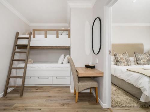 a bedroom with bunk beds and a desk and a ladder at Nadora's Rest in Kirkwood