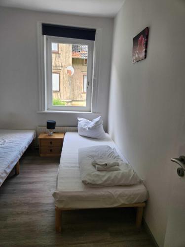 a bedroom with two twin beds and a window at Monteurwohnungen Lerbachtal in Osterode
