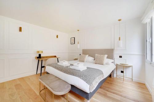une chambre blanche avec un lit et une table dans l'établissement Cosy apartment - 1BR-2P - Gros-Caillou-Invalides, à Paris