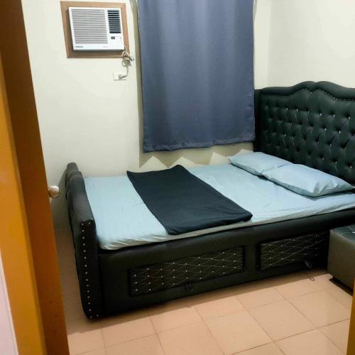 a bed in a room with a mirror at Yumi Condotel 1 in Dumaguete