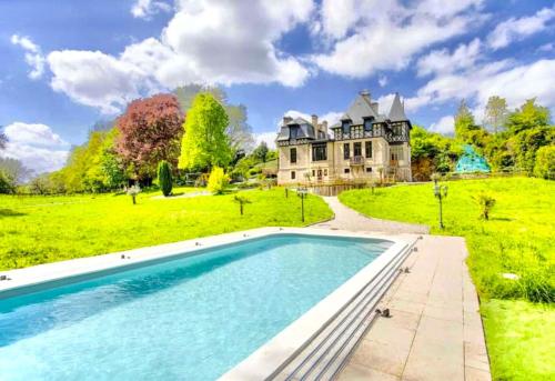 un domaine avec une piscine devant une maison dans l'établissement Le Manoir du Val, à Douvres-la-Délivrande