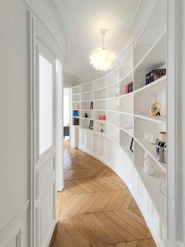 un couloir avec des murs blancs et un escalier blanc dans l'établissement Amazing refurbished flat in Paris V, à Paris