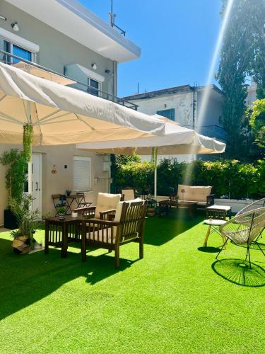 a patio with a table and chairs and an umbrella at Cinque Stelle Apartments in Glífa
