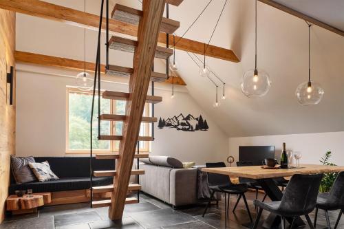a living room with a wooden staircase and a table at Apartmán Bedřich VI. in Bedřichov