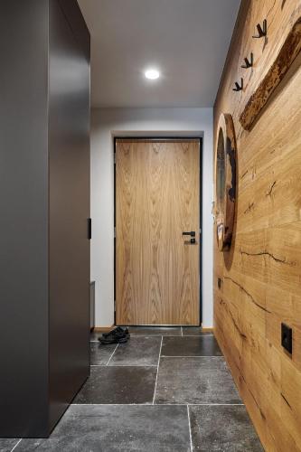 a hallway with a wooden door and a tile floor at Apartmán Bedřich VI. in Bedřichov