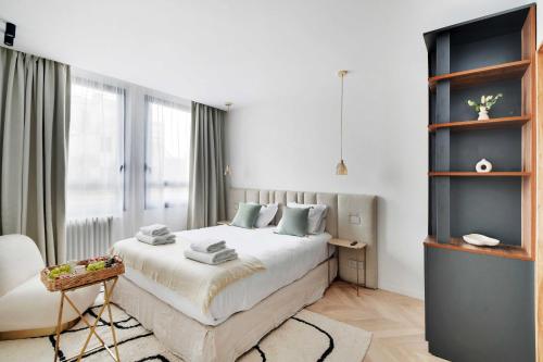 une chambre blanche avec un lit et une chaise dans l'établissement Elegant apartment - 3BR-8P - Champs-Elysées, à Paris