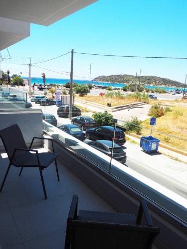 a balcony with a view of a parking lot with cars at Golden Sand Suites in Anavissos