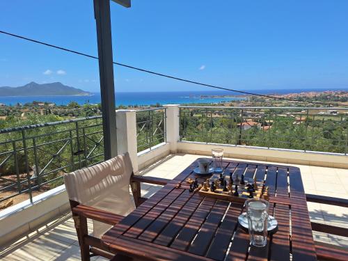 a table and chairs on a balcony with a chess board at Villa Tapia in Methoni