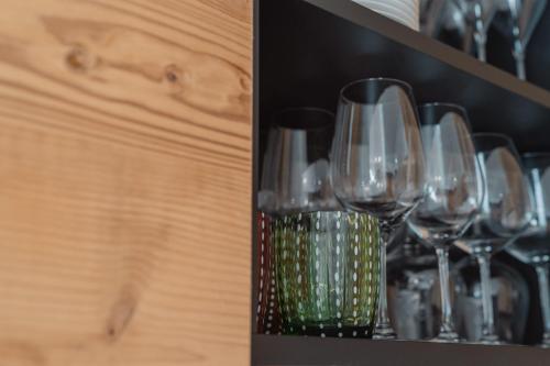 a bunch of wine glasses sitting on a shelf at Apartments Hofmann in Prateria