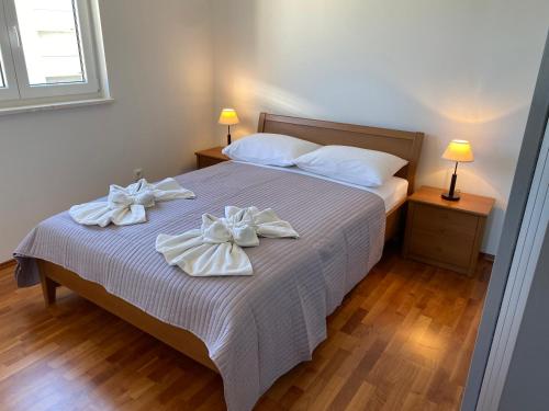 a bedroom with a bed with two bows on it at Apartment Bumbar Sunset in Rogoznica