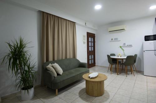 a living room with a green couch and a table at casa NEFELI in Karteros