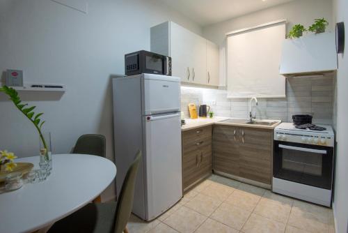 a kitchen with a white refrigerator and a table at casa NEFELI in Karteros