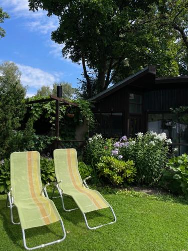 two chairs sitting in the grass in a yard at Summer chalet in the heart of Riga in Rīga