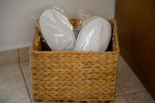 a wicker basket with two white shoes in it at casa NEFELI in Karteros
