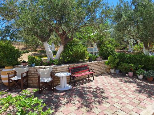 a patio with a bench and chairs and a table at Villa Tapia in Methoni