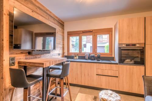 une cuisine avec des armoires en bois et une table en bois dans l'établissement Studio Arbois - Welkeys, à Megève