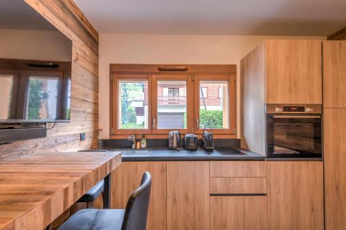 une cuisine avec des placards en bois et un comptoir en bois dans l'établissement Studio Arbois - Welkeys, à Megève