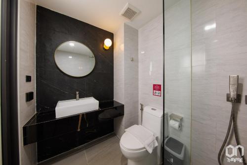 a bathroom with a toilet and a sink and a mirror at ON Thapae Gate Chiangmai in Chiang Mai
