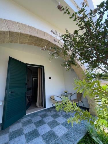 a green door of a building with a table and chairs at Villa Salentina in Sant'Isidoro