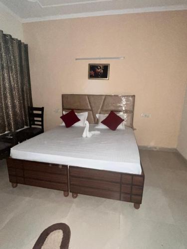 a bed with red pillows in a room at Comfort Homes in Panchkula